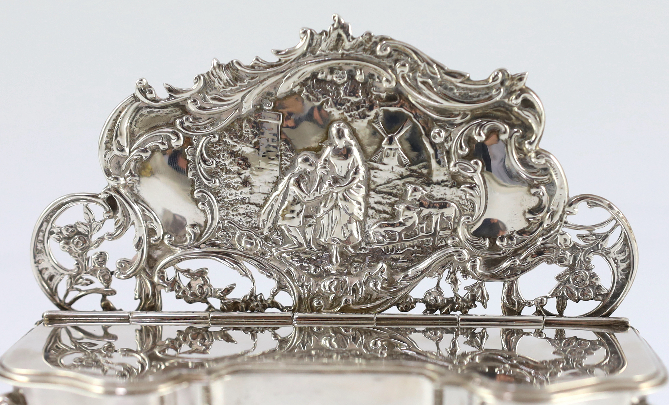 An Edwardian embossed silver novelty trinket box, modelled as a dressing table with raised back, on cabriole legs, by William Comyns